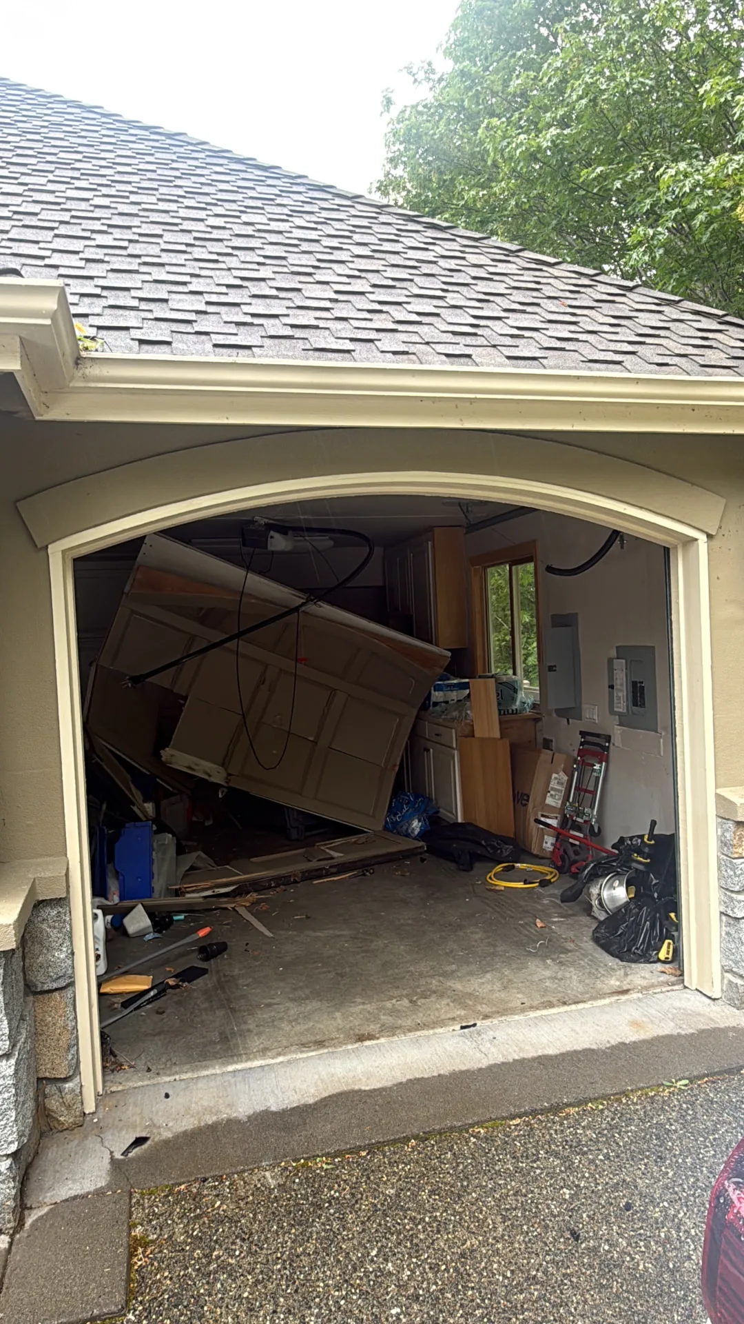 Garage door off track and collapsed inside the garage before repair